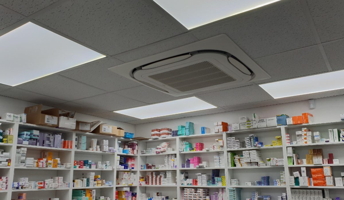 Inside pharmacy with shelves and drugs in air conditioned room