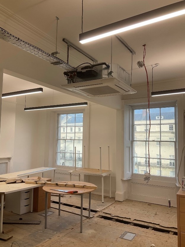 Room under renovation with air conditioning unit hanging from ceiling