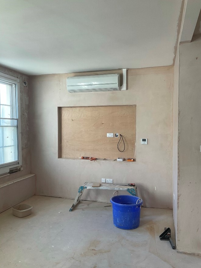 Unpainted plastered wall with air conditioning unit