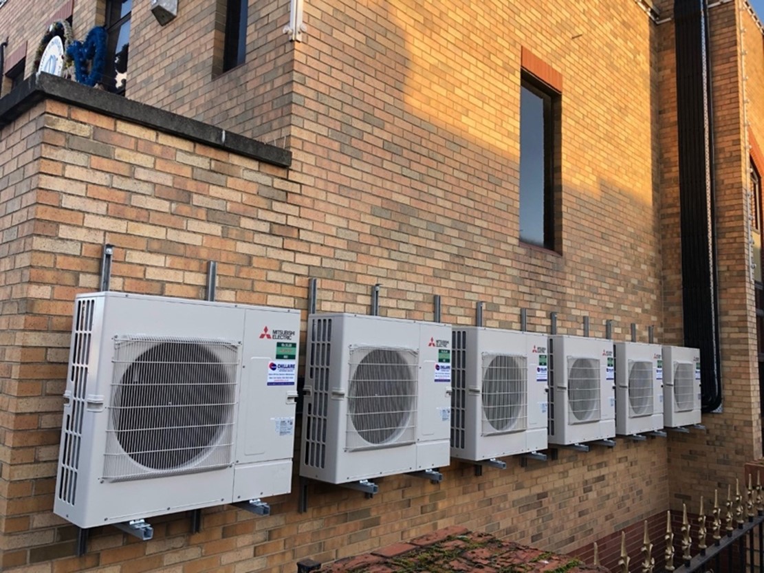 6 air conditioning ventilation units outside brick building