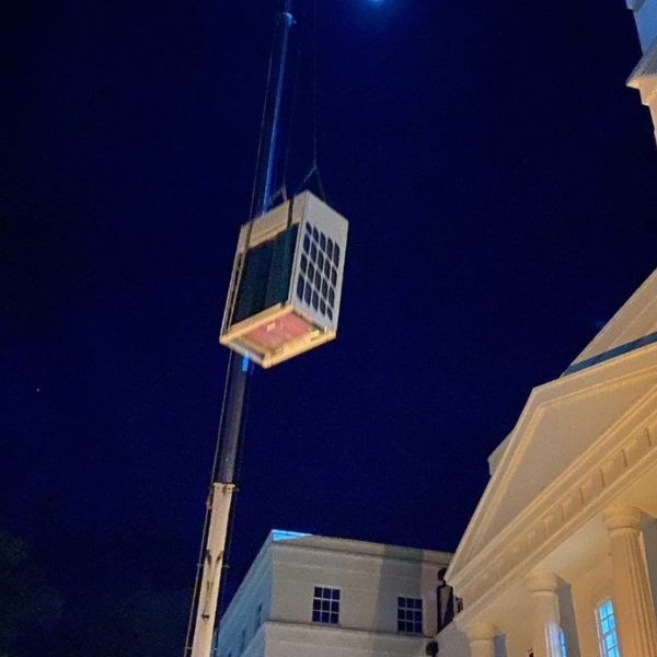 Air conditioning unit being lifted by crane