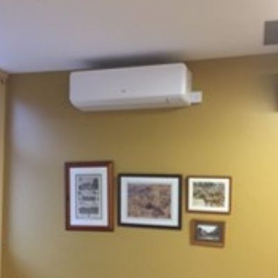 Air conditioning unit above framed pictures
