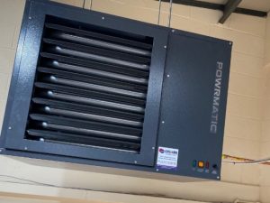 Powrmatic air ventilation system hanging from brick wall