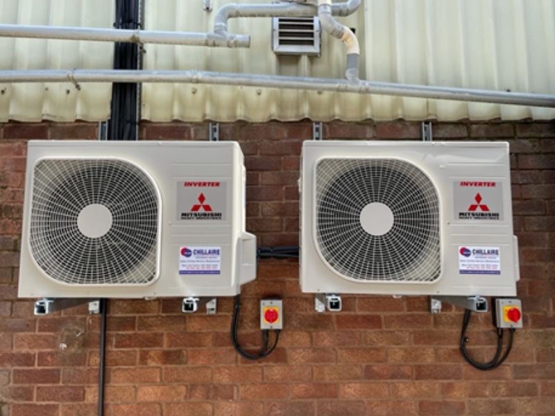 Showroom heat pump air conditioning units outside on brick wall