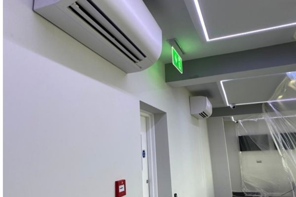 Air conditioning units on wall next to fire exit