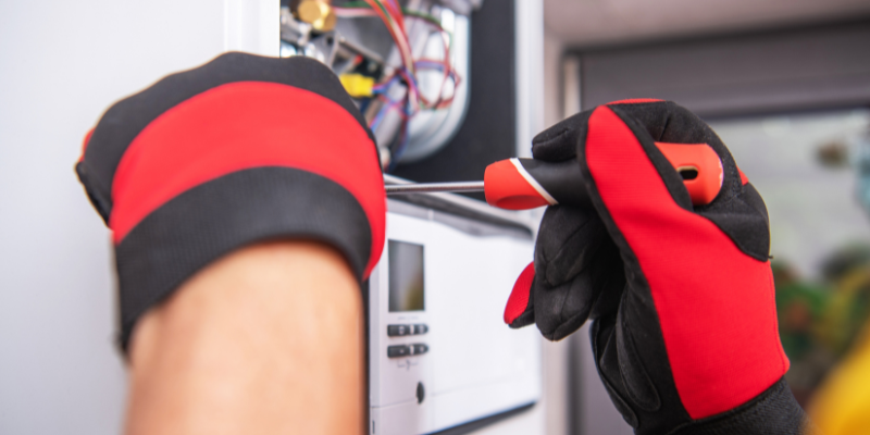 Man with screwdriver fixing air conditioning central unit