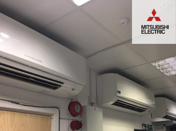 Untitled design (5) row of mitsubishi electric air con units on wall inside building