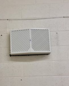 Ventilation shaft on white brick wall